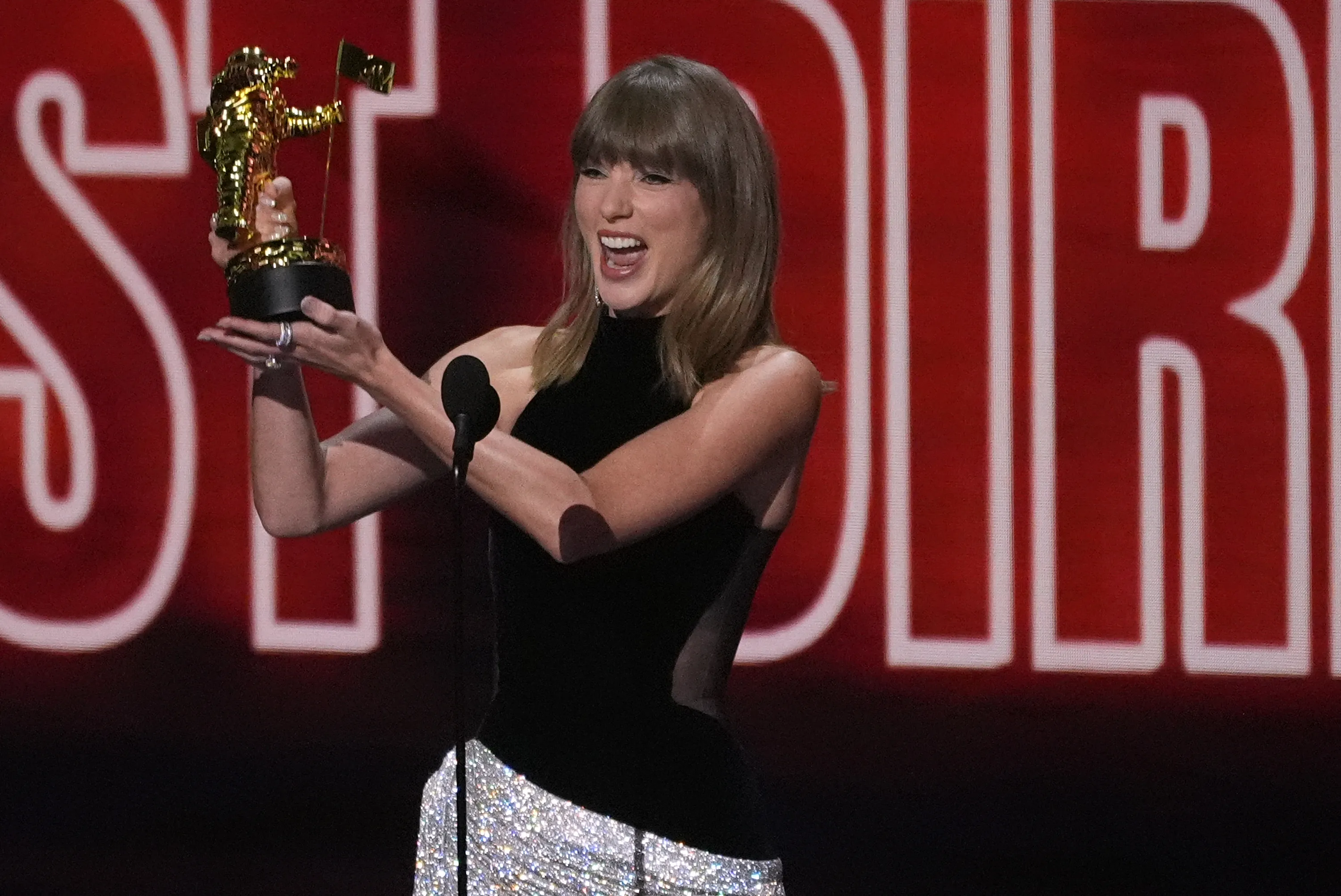 Taylor Swift holding her MTV VMA Artist Director Honors award.
