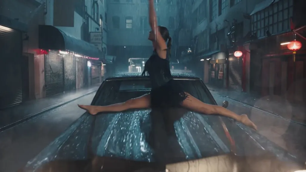 Taylor Swift doing a split on a car in the rain.
