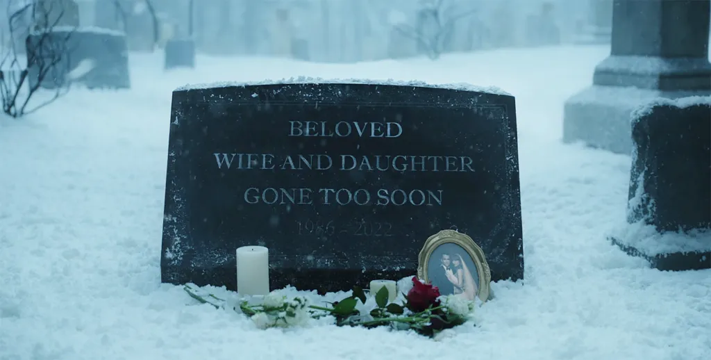 A snowy gravestone reads