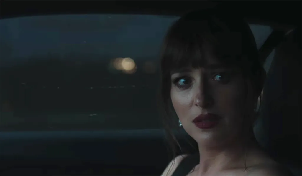 Taylor Swift in a car at night, looking worried.