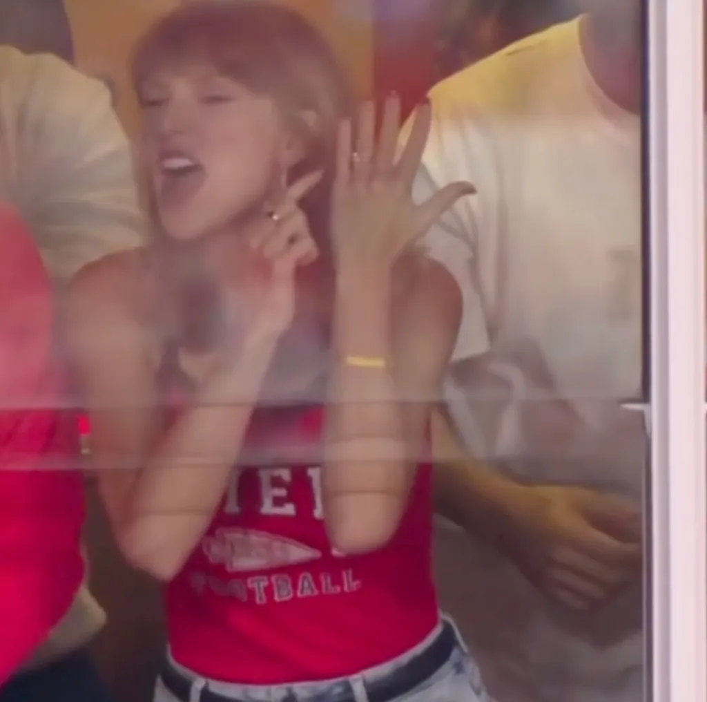 Taylor Swift points to her wedding ring during a Chiefs game.