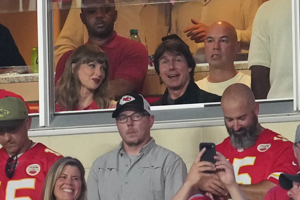Taylor Swift , in a red tank top, and Tom Cruise, in a black shirt, watching the game.