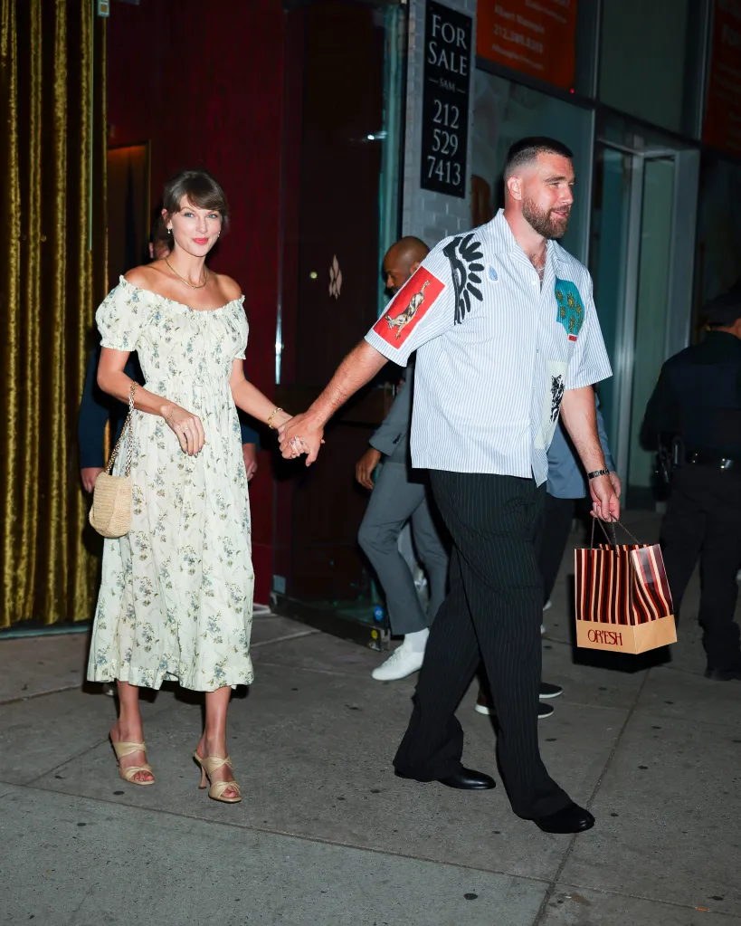 Taylor Swift and Travis Kelce walking hand-in-hand in New York City.