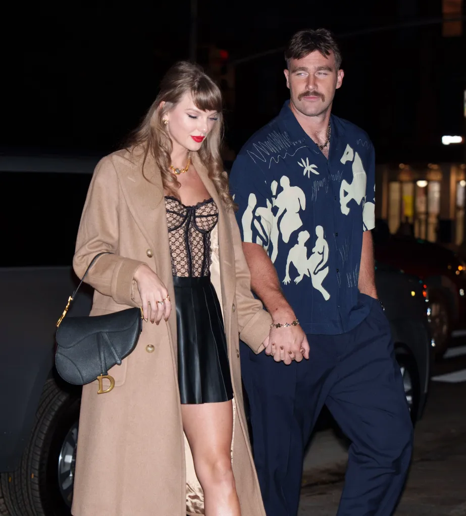 Taylor Swift and Travis Kelce holding hands while walking in New York City.