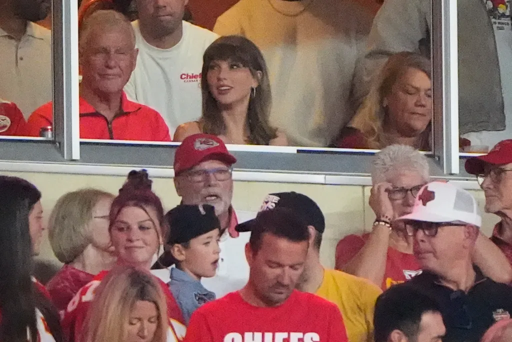 Taylor Swift in a suite with her father Scott Swift and mother Andrea Swift at an NFL football game.