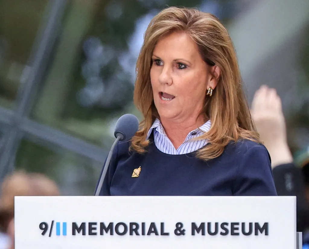Terry Strada speaking at a podium during the 25th anniversary of the September 11 attacks.