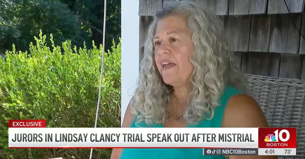 A woman with curly gray hair speaks, wearing a teal top and a necklace with small charms. Text overlay reads