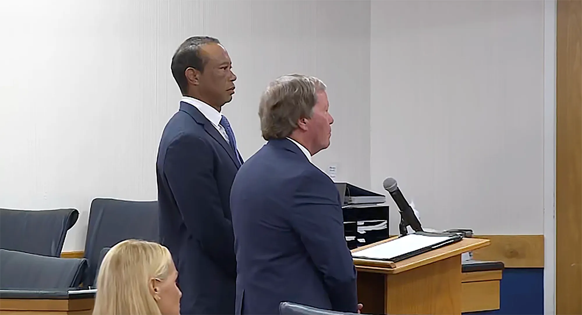 Tiger Woods standing in court next to his lawyer.