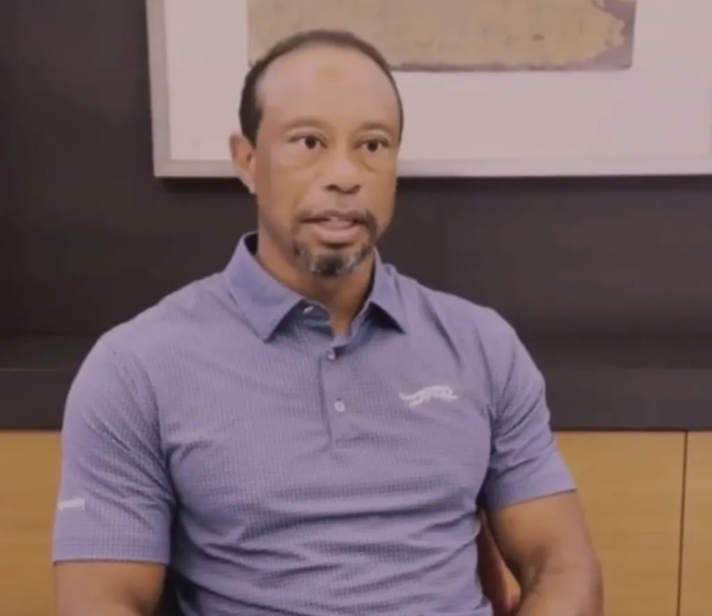 Tiger Woods with a graying beard and wearing a gray polo shirt.