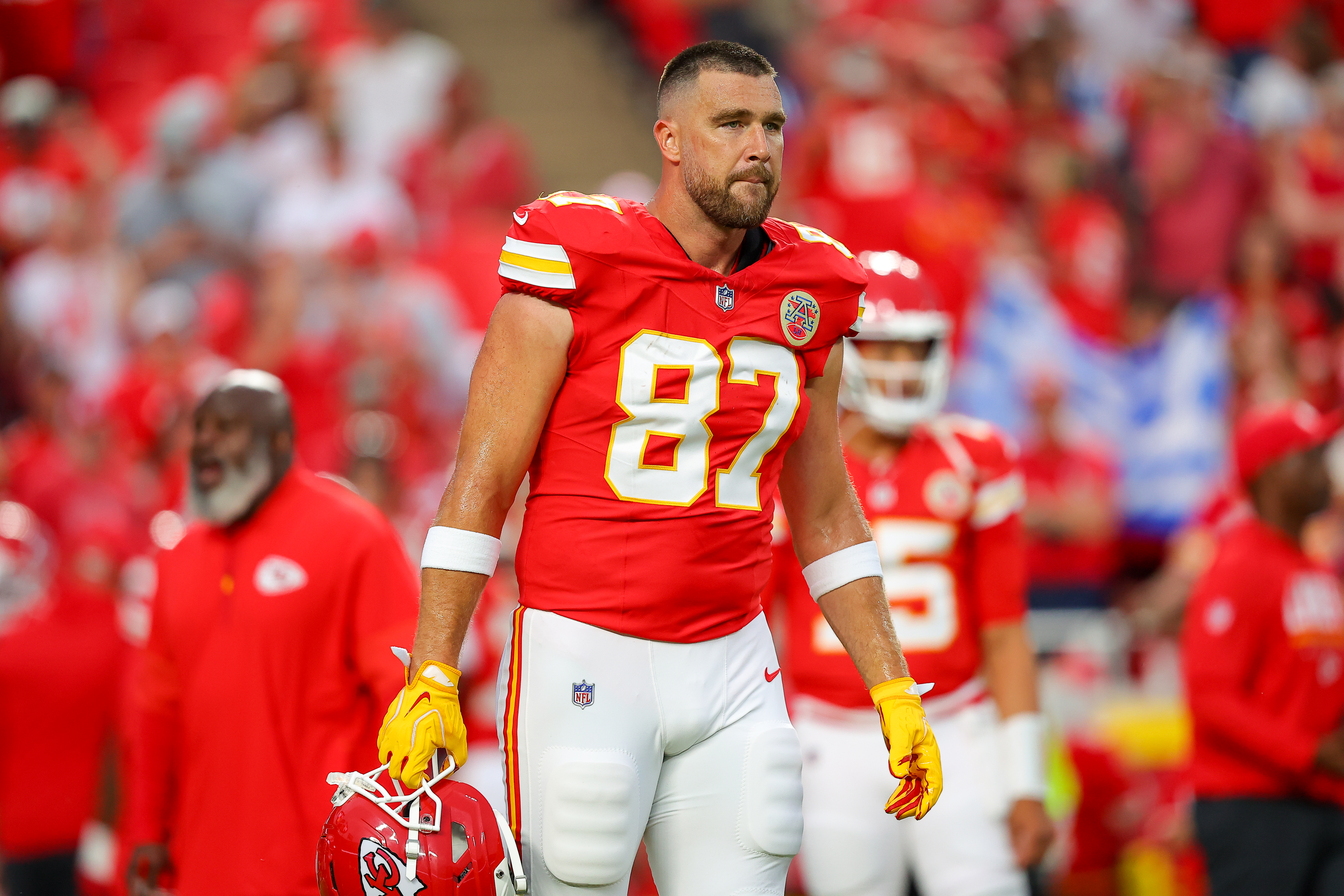 Kansas City Chiefs tight end Travis Kelce #87 walks on the field in a red jersey and white pants during pregame warmups.
