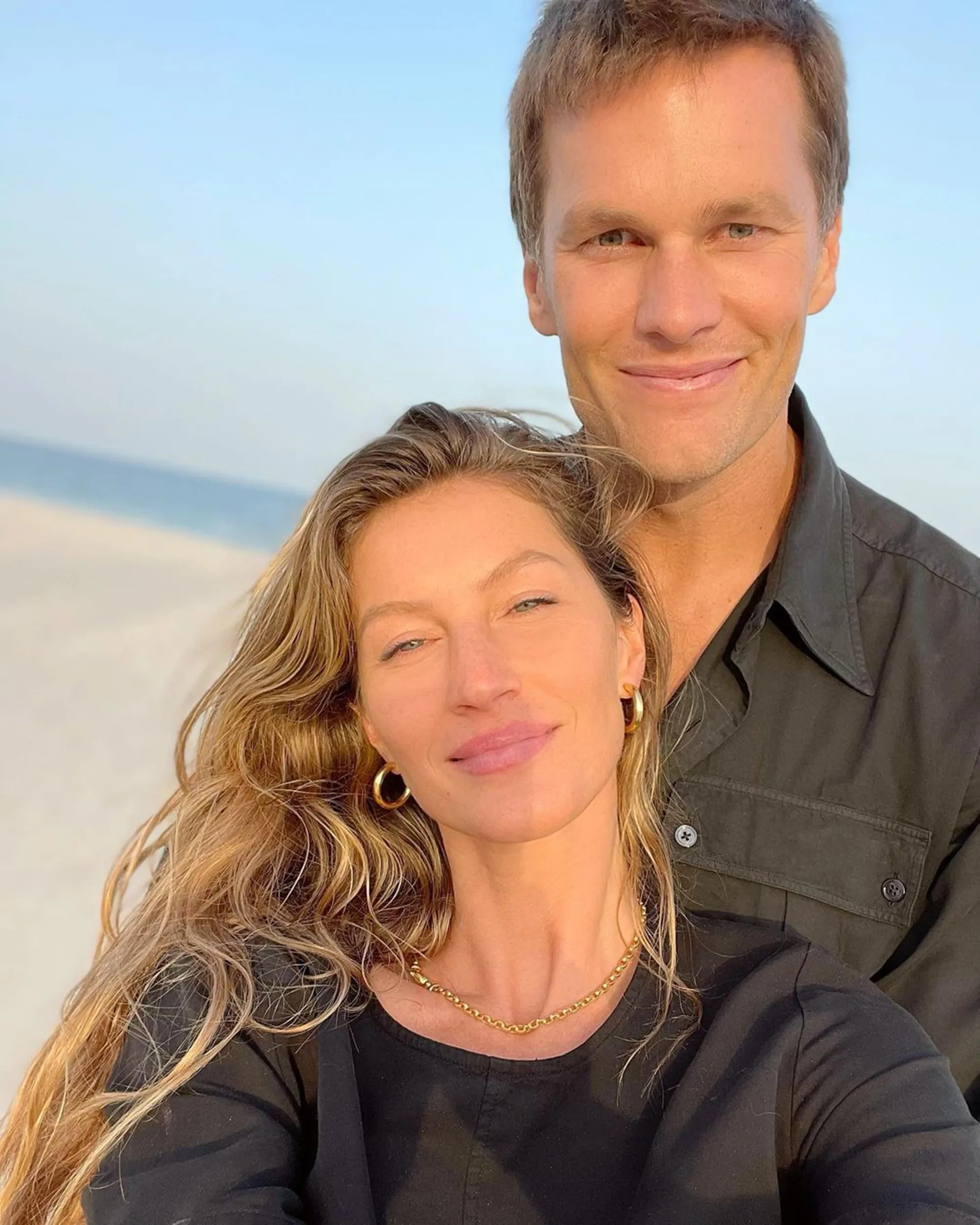 Tom Brady and Gisele Bündchen posing together at the beach.