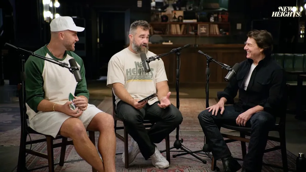 Travis Kelce, in a white and green shirt, white shorts and white baseball cap, and Jason Kelce, in a white 'New Heights' T-shirt and black pants, and Tom Cruse, in a black shirt, white T-shirt and black pants, 