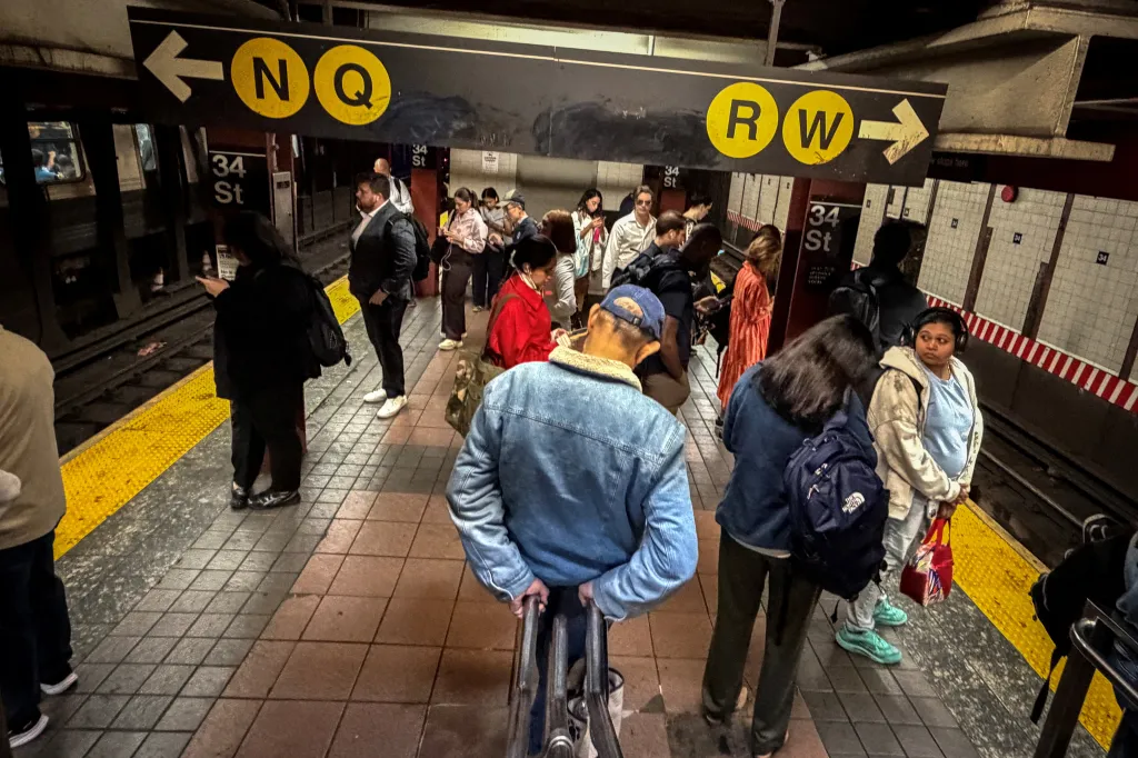 Commuters wait for a train at a subway station in Manhattan, New York.
