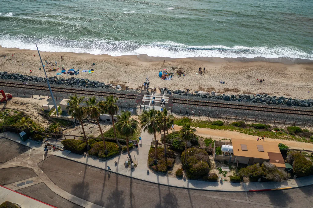 Aerial view of train tracks running alongside a beach in San Clemente, California.