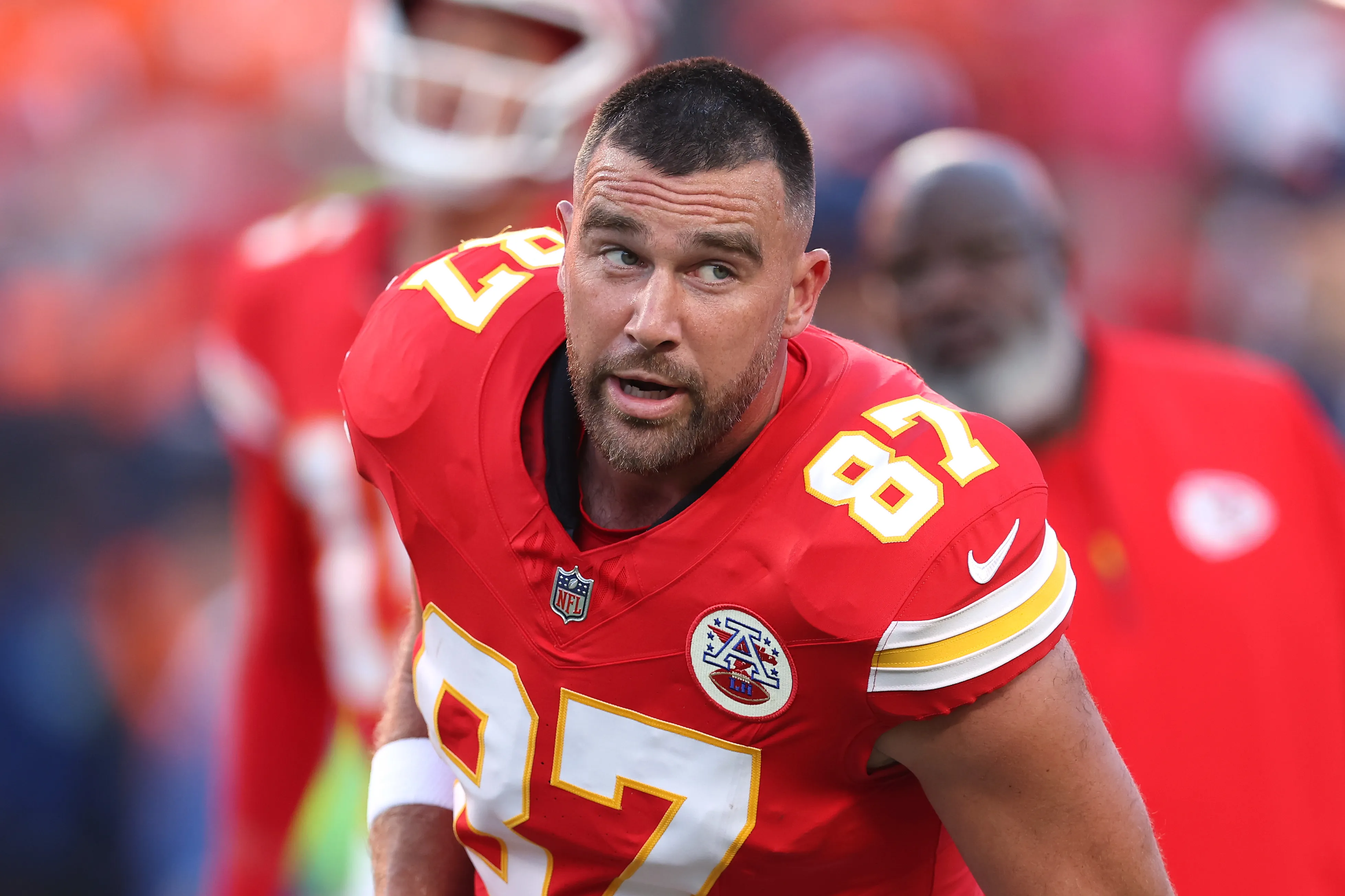 Travis Kelce looking on from the field during an NFL game.