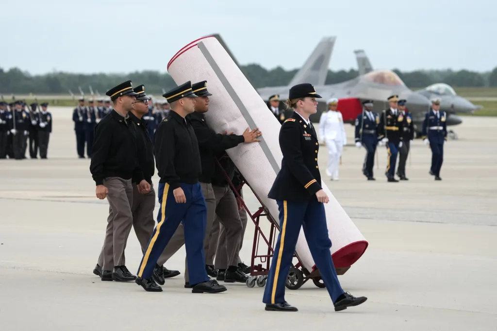 US Air Force crew moving a red carpet at Joint Base Andrews.