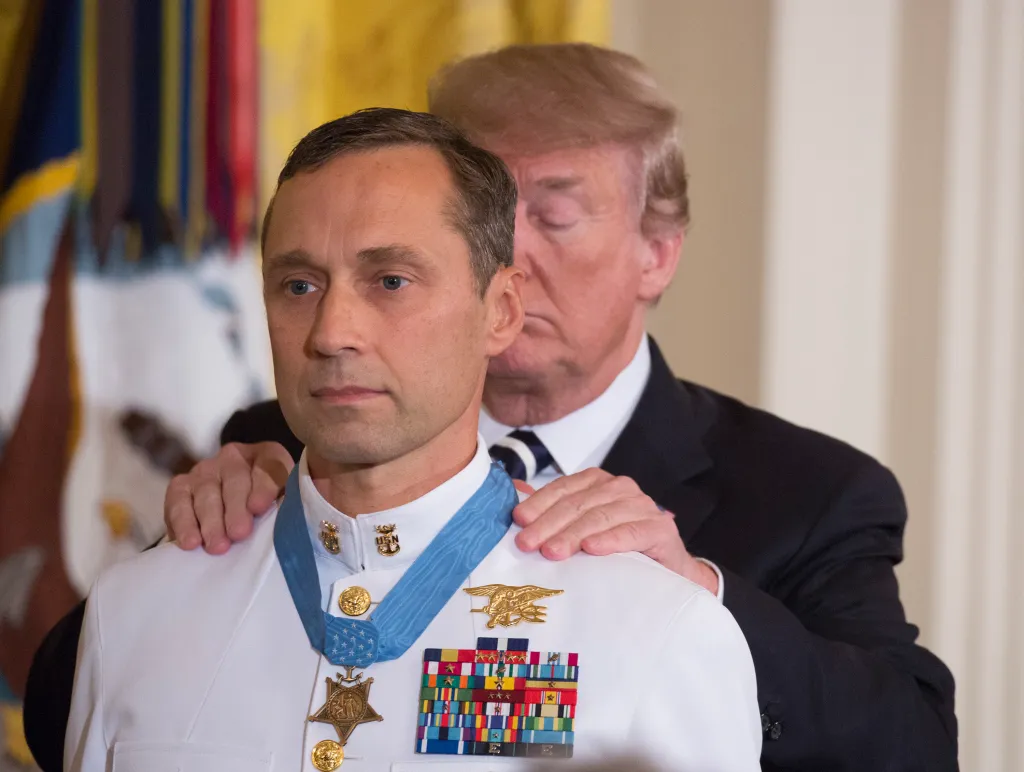 President Donald Trump places the Medal of Honor around the neck of retired Master Chief Petty Officer Britt K. Slabinski.