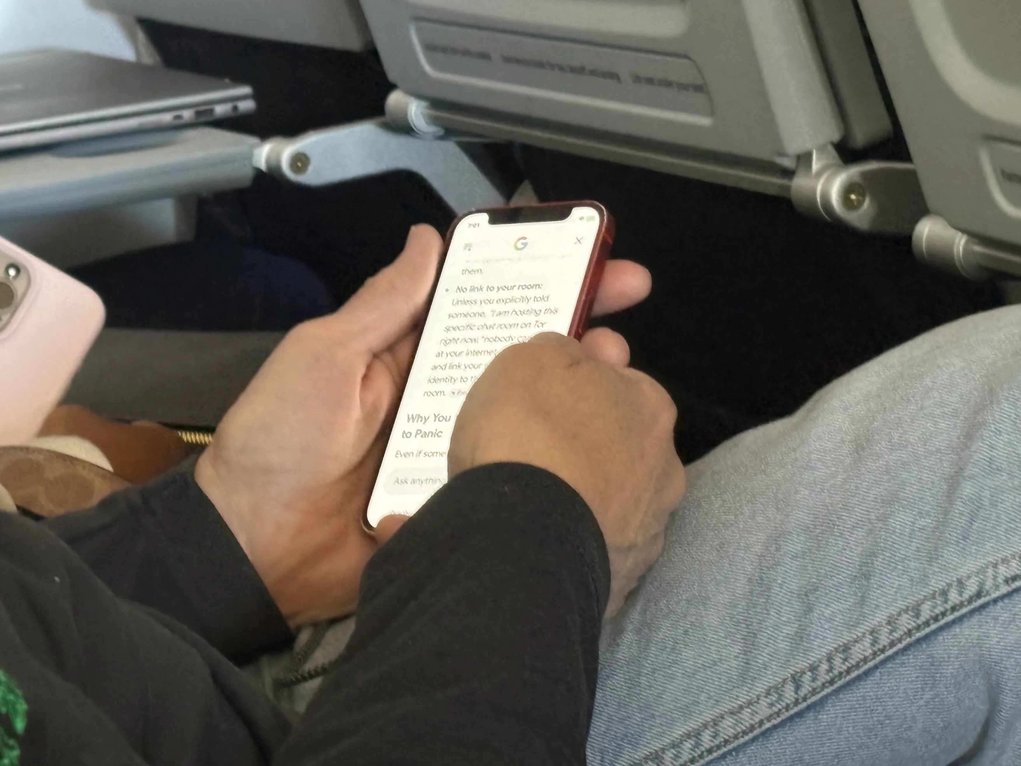 Jim Thornton on a plane, holding a phone displaying a Google search result about chatroom anonymity.