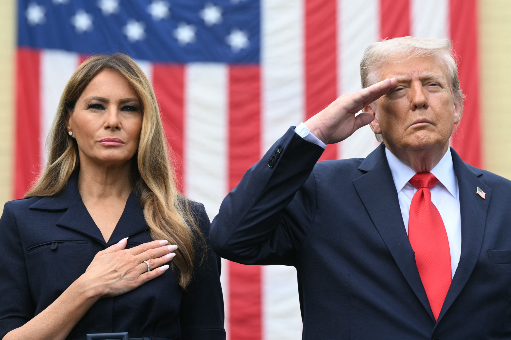 President Donald Trump salutes while First Lady Melania Trump places her hand over her heart during a 9/11 observance.