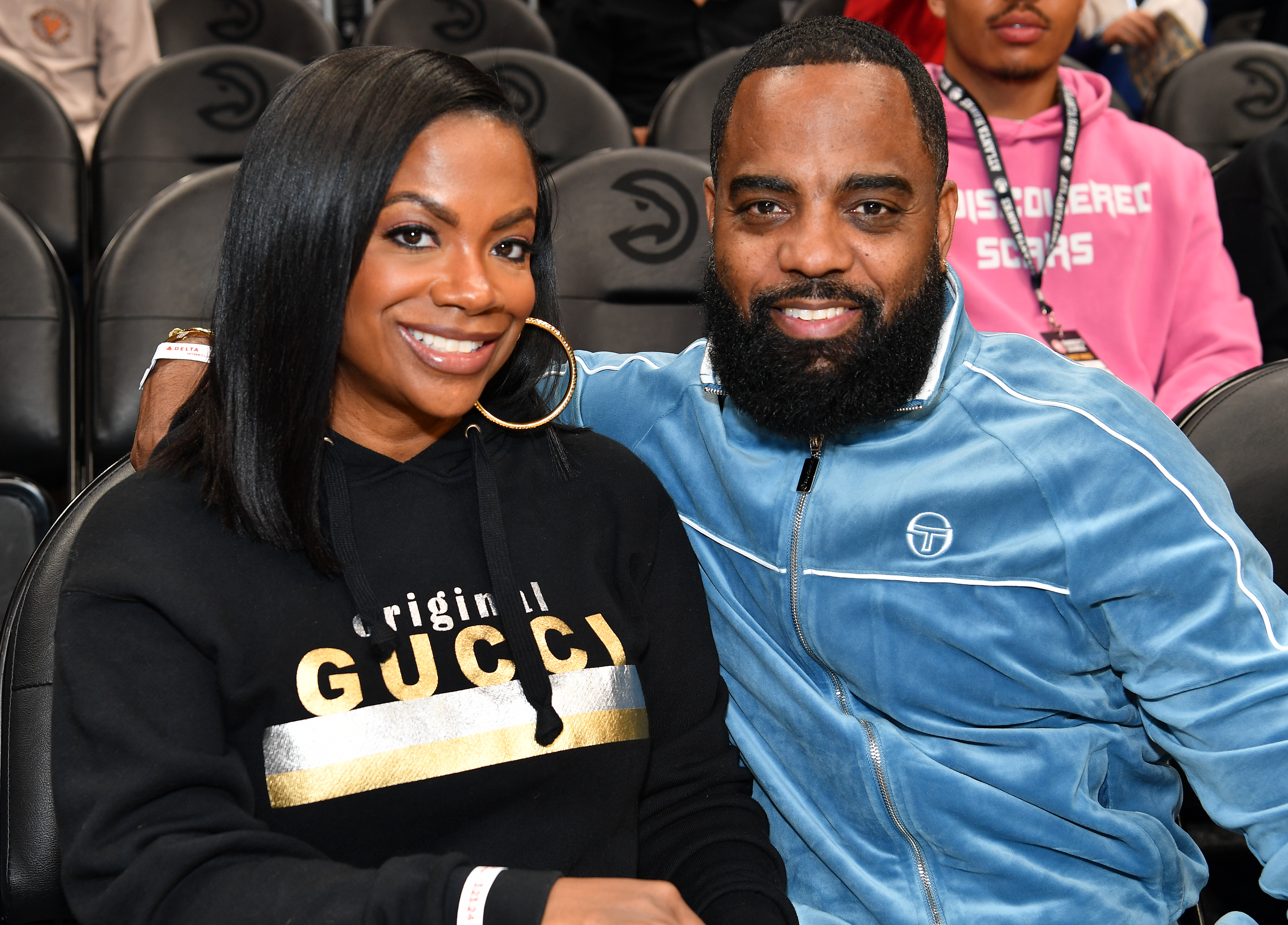 Kandi Burruss and Todd Tucker smiling while attending a basketball game.
