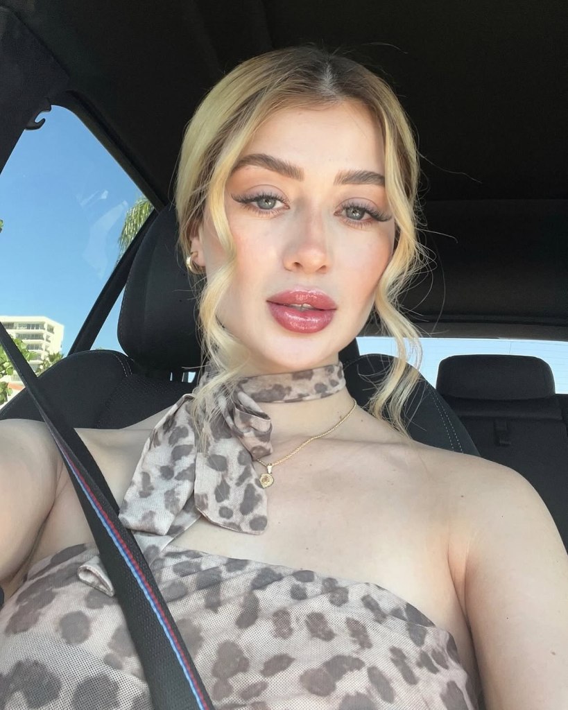 Valeria Marquez, a blonde woman wearing a leopard print top and scarf, in a car.
