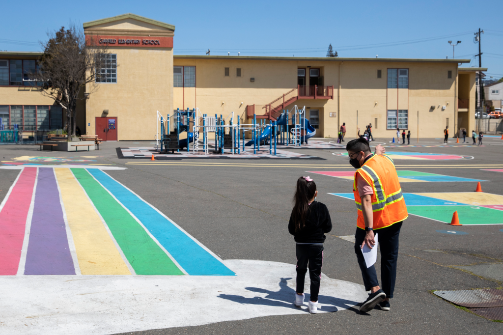 Vice Principal Edgar Rodriguez-Ramirez instructing a student on the first day of partial in-person instruction at Garfield Elementary School.