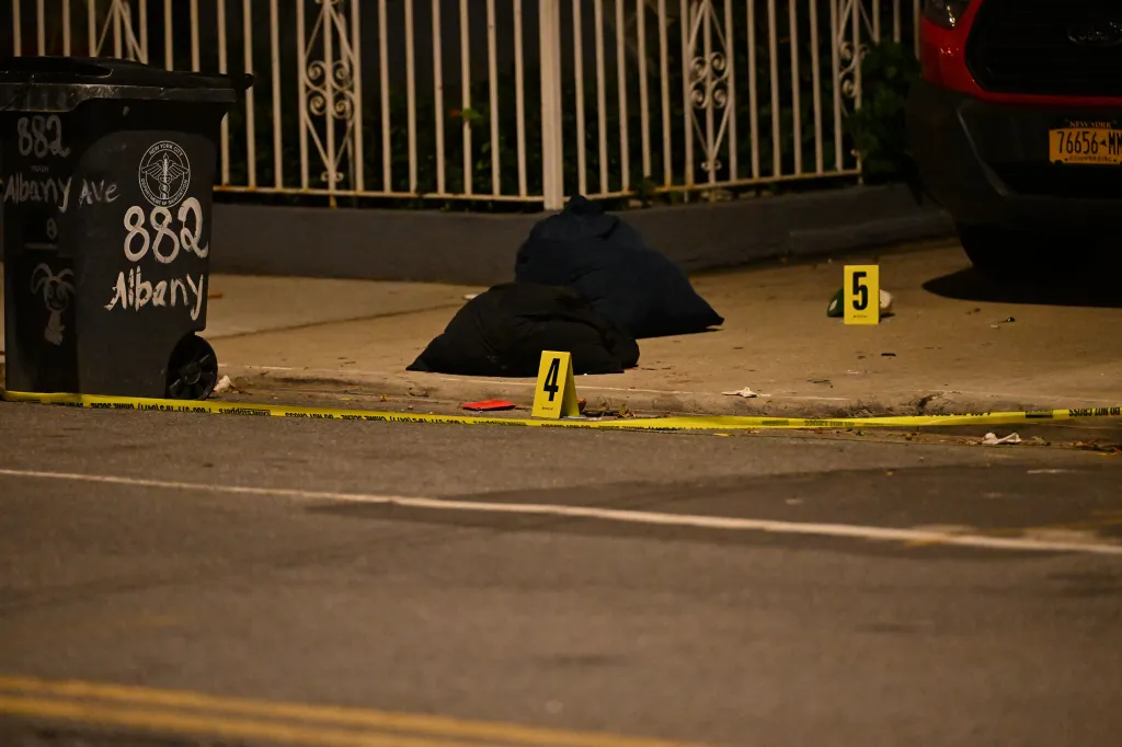 Yellow crime scene tape on a sidewalk where a 25-year-old was stabbed in Brooklyn.