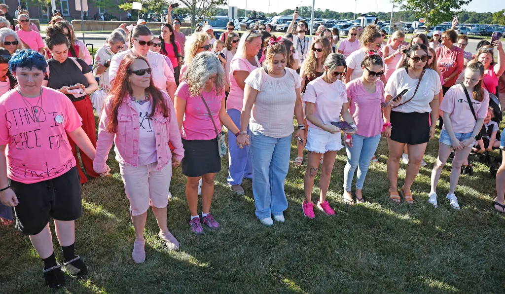 Renee Kimball and Lindsay Clancy supporters holding hands for a moment of silence.