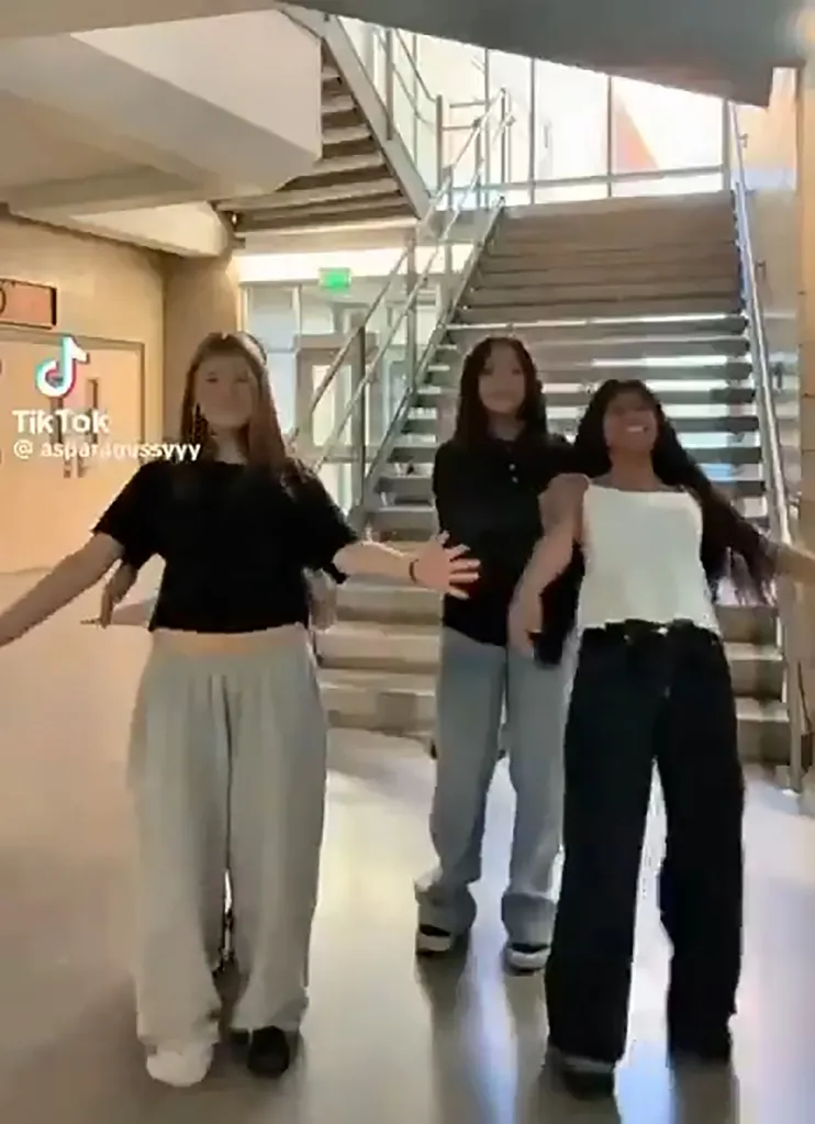 Three teenage girls dancing in a hallway, mocking Charlie Kirk's death.