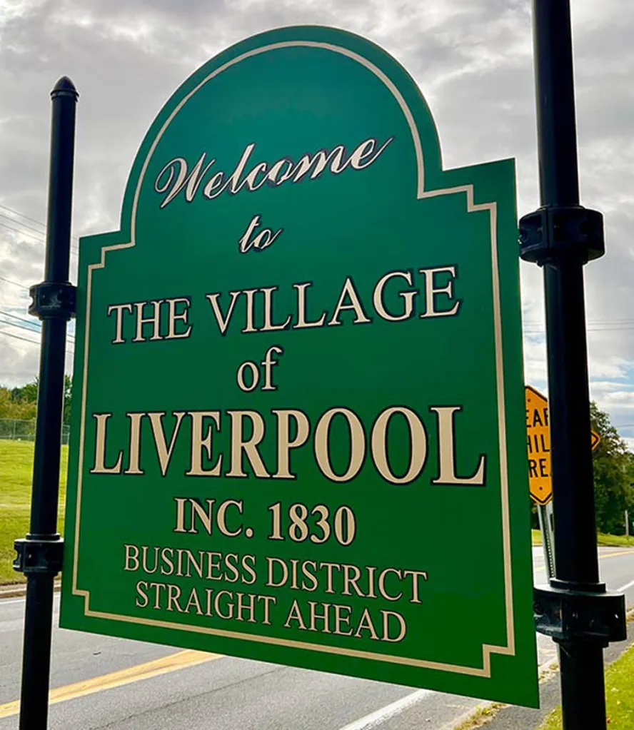 Green welcome sign to the Village of Liverpool, incorporated in 1830, with directions to the business district.