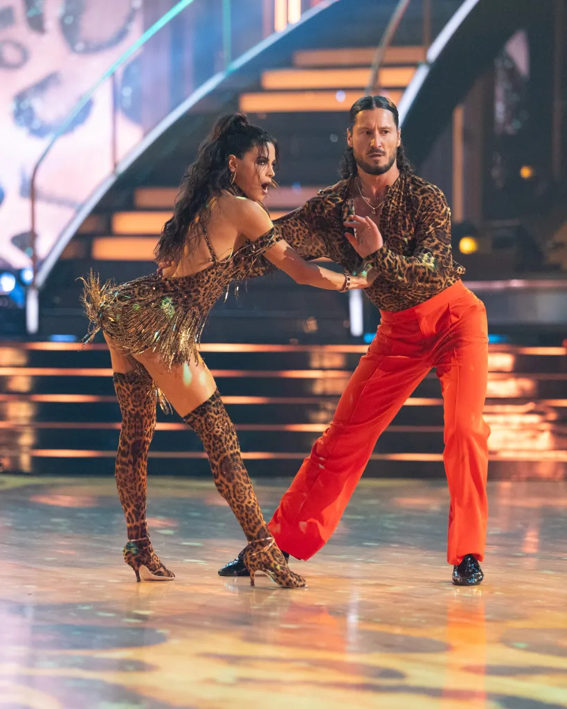 Jenna Dewan and Valentin Chmerkovskiy dance on stage in animal print outfits, with Chmerkovskiy wearing bright orange pants.