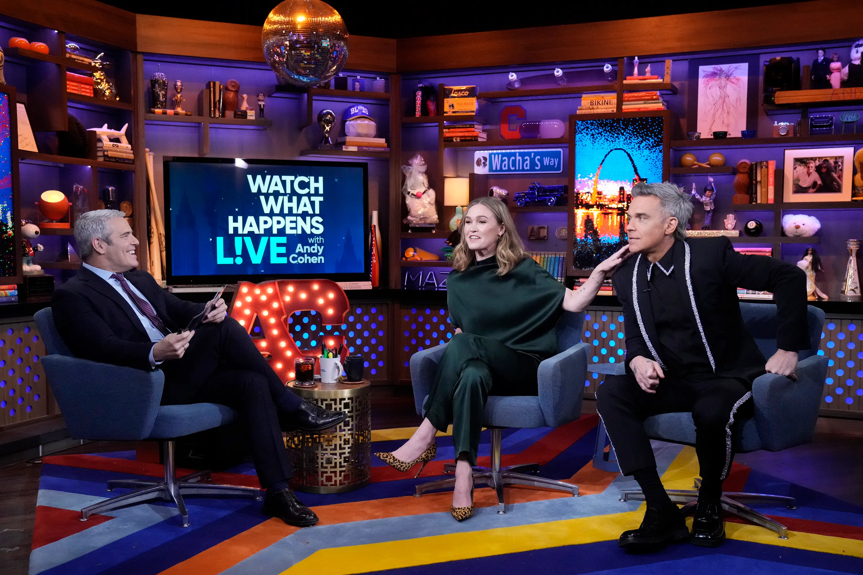 Andy Cohen, Julia Stiles, and Robbie Williams on the set of 