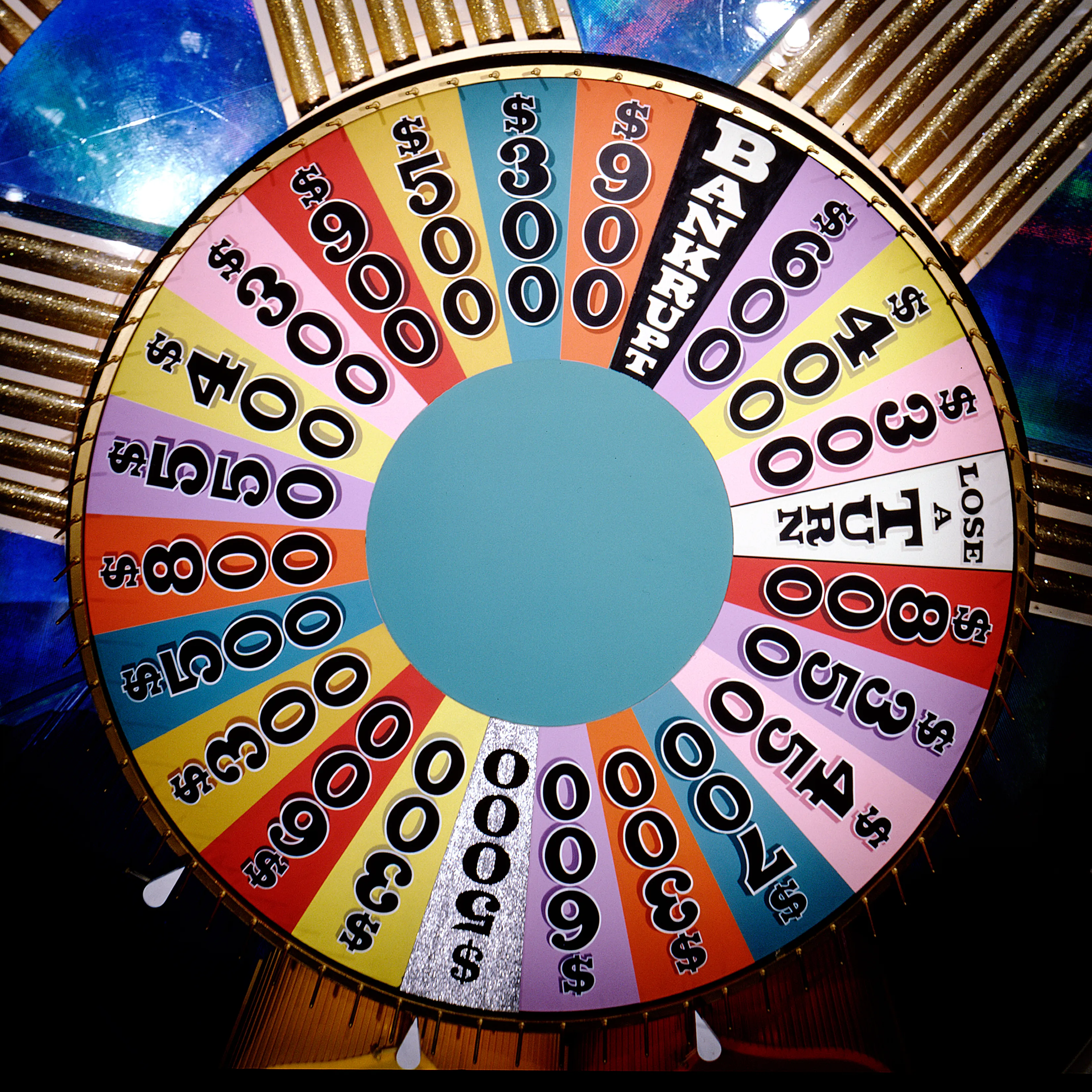 A colorful Wheel of Fortune wheel with dollar amounts and 