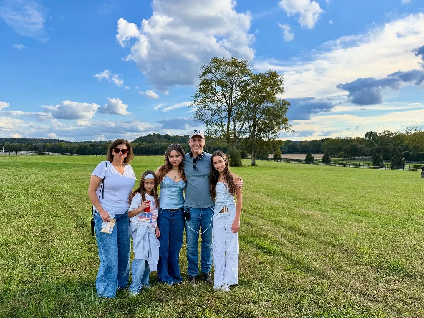 Chad Lowe and his family pose for a photo in a grassy field.