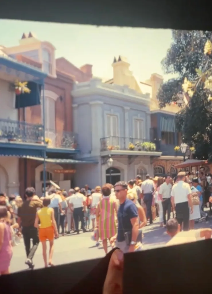 Vintage photo of a crowd walking through a lively street with multi-story buildings, including a man in a blue shirt with sunglasses who is believed to be a time traveler.
