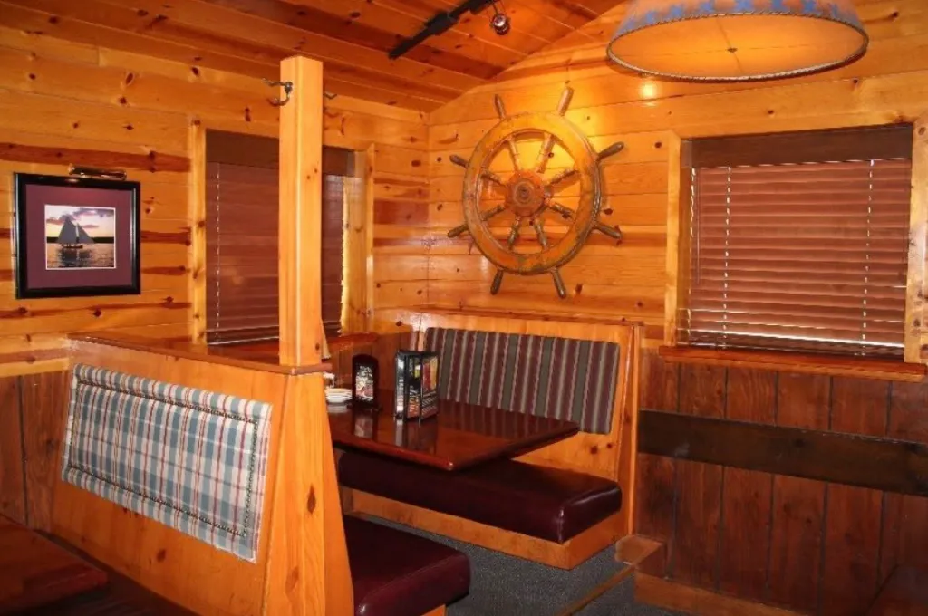 Interior of Tahoe Joe's Steakhouse with wooden booths and nautical decor.