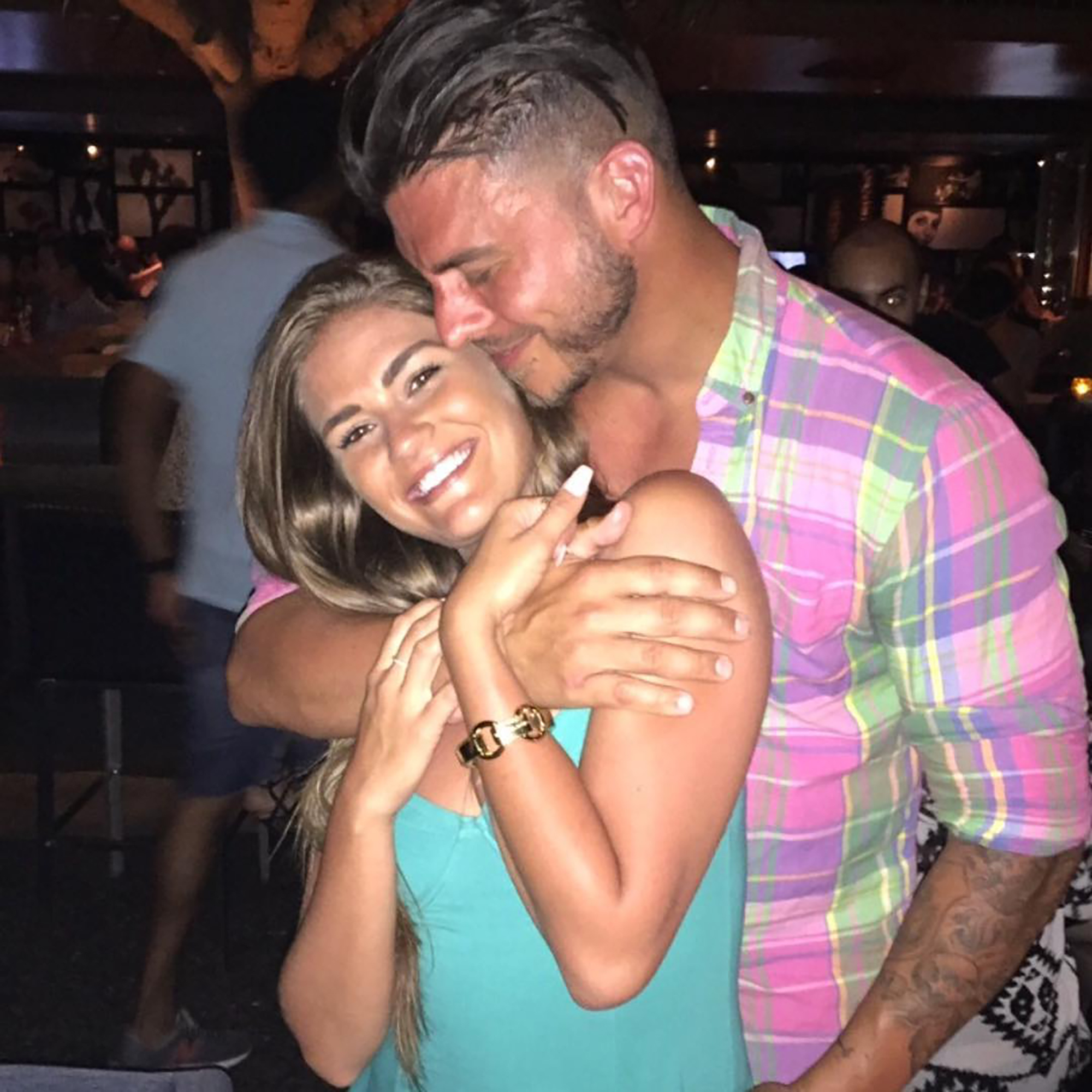 Jax Taylor with his arm around Brittany Cartwright's neck and shoulders, both smiling.