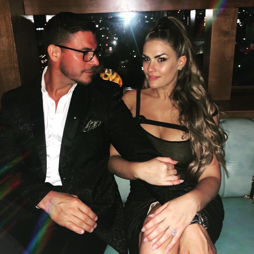 Jax Taylor and Brittany Cartwright sitting together in a restaurant with a city view.