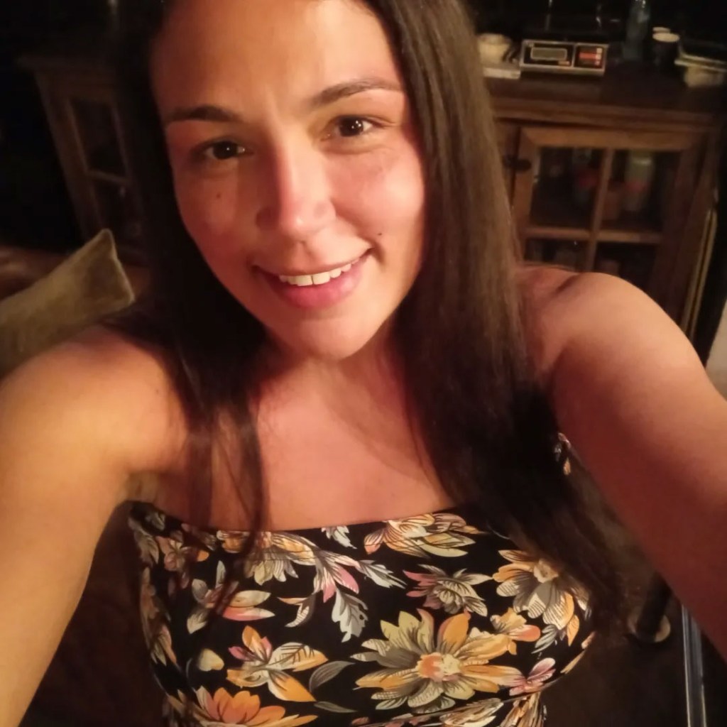 Amber Eggers smiling in a floral strapless top.