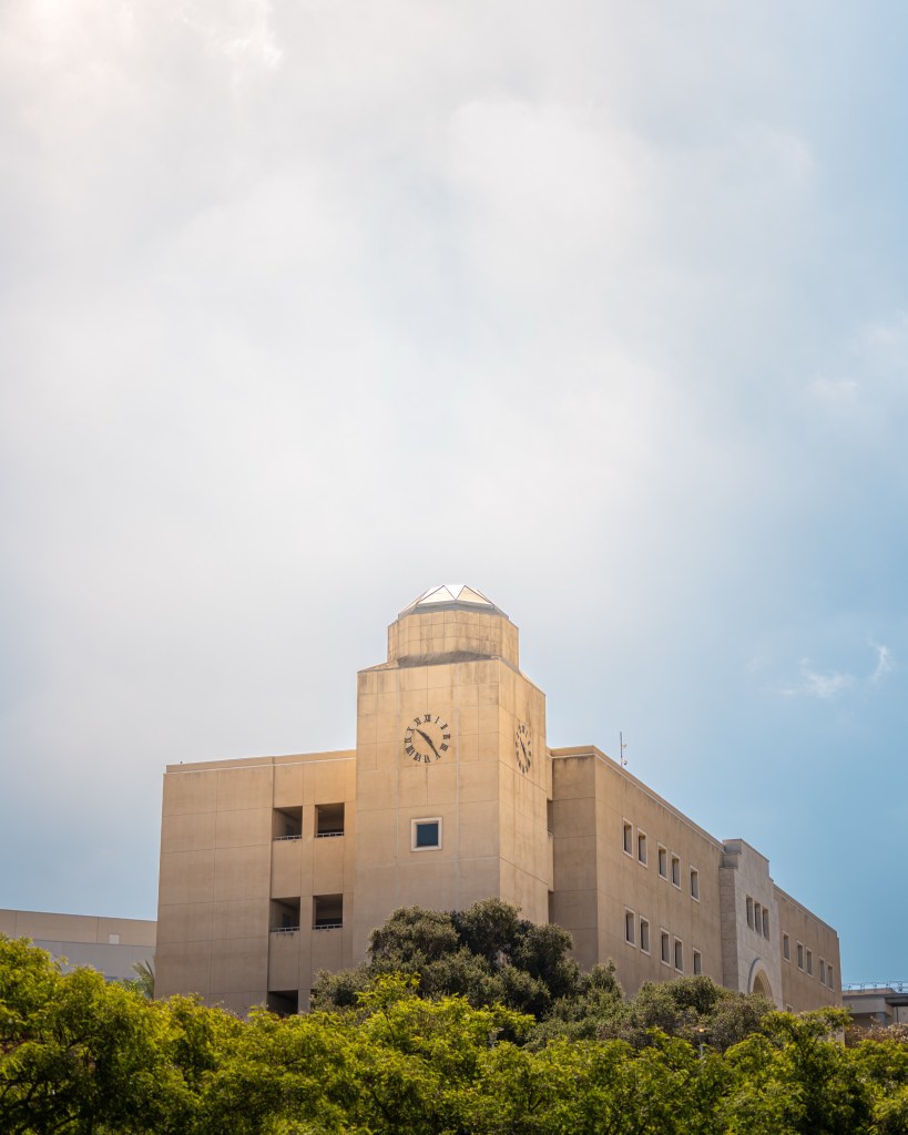 A low-angle photo of a clock tower at California State University, San Marcos, under a bright sky.