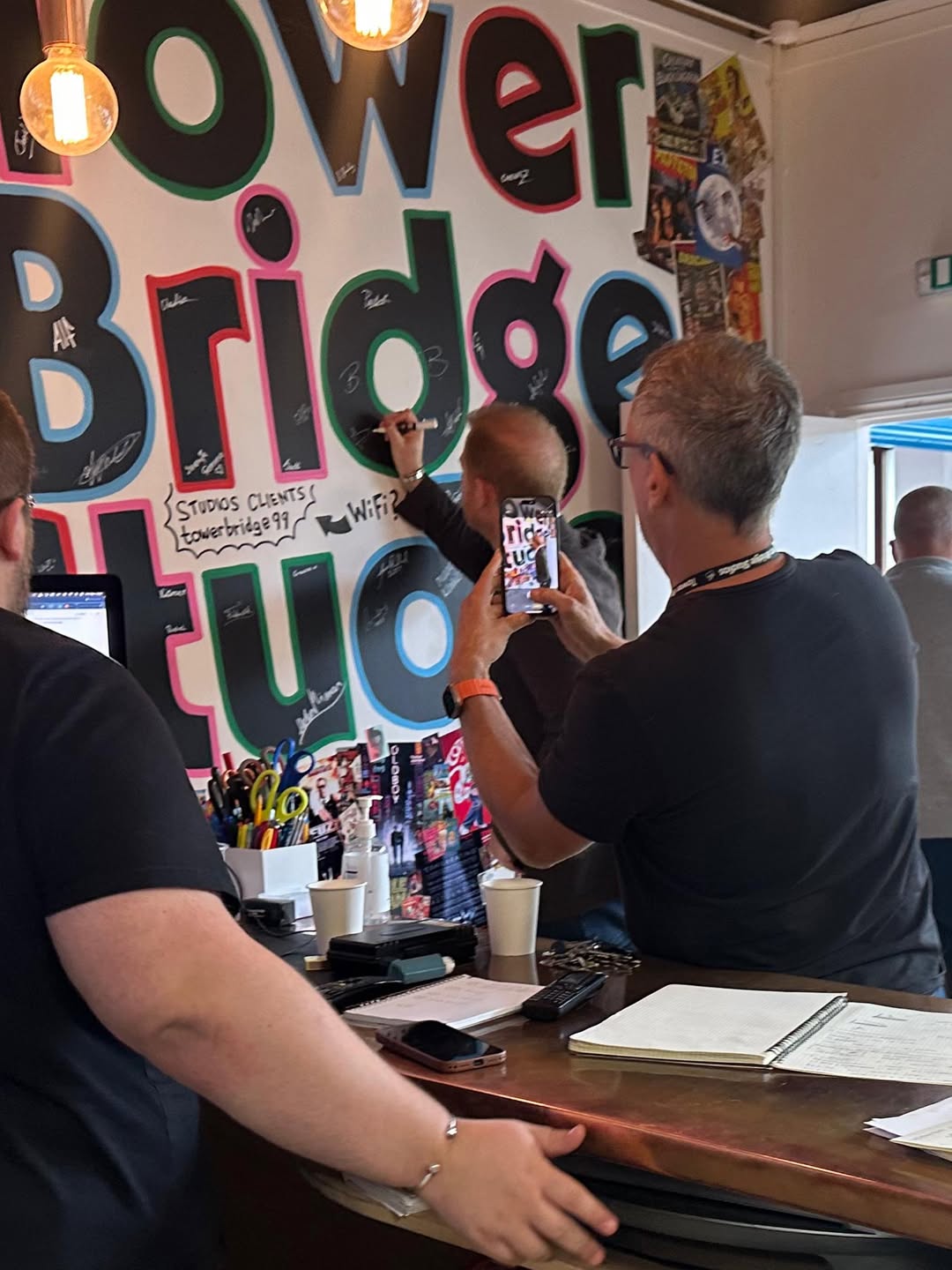 Prince Harry signing his autograph on a wall at Tower Bridge Studios.