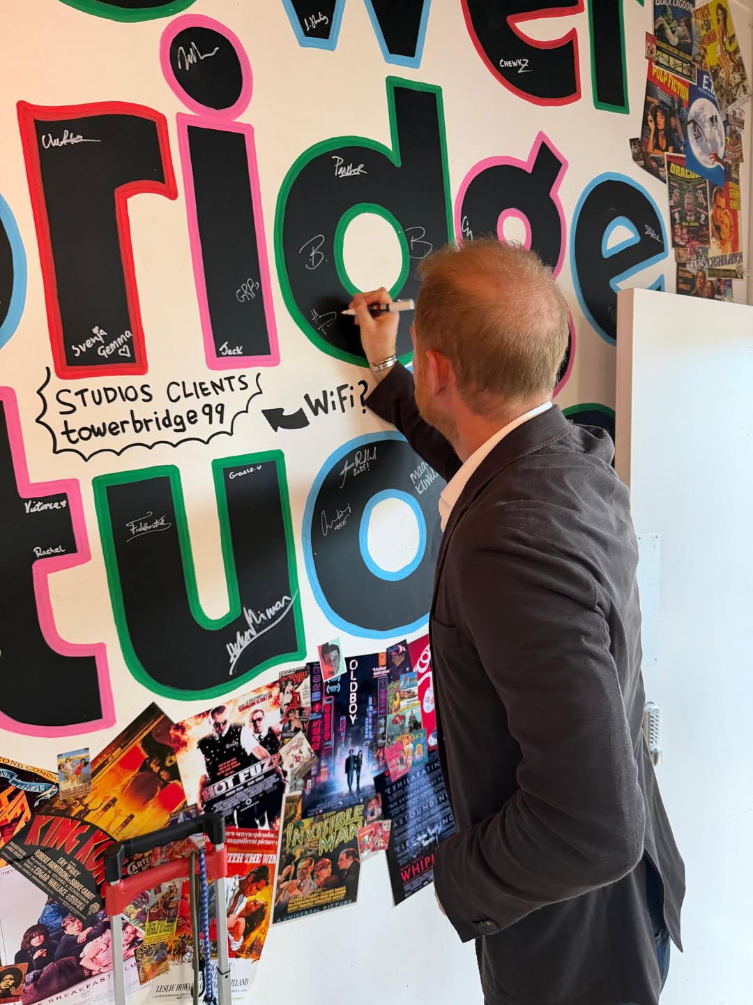 Prince Harry signing a wall at Tower Bridge Studios.