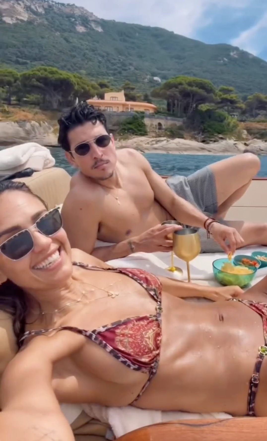 A man and woman snacking on a boat.