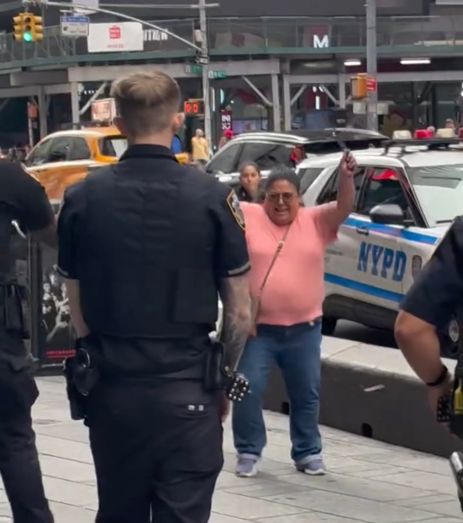 A woman with a knife confronts a police officer in Times Square.