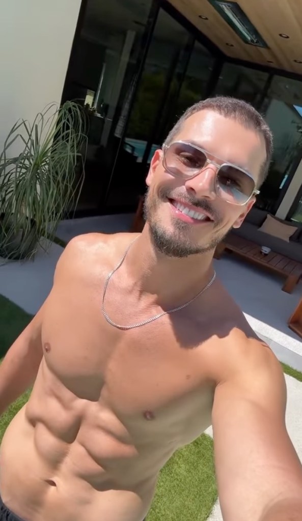 Gleb Savchenko posing shirtless outdoors.