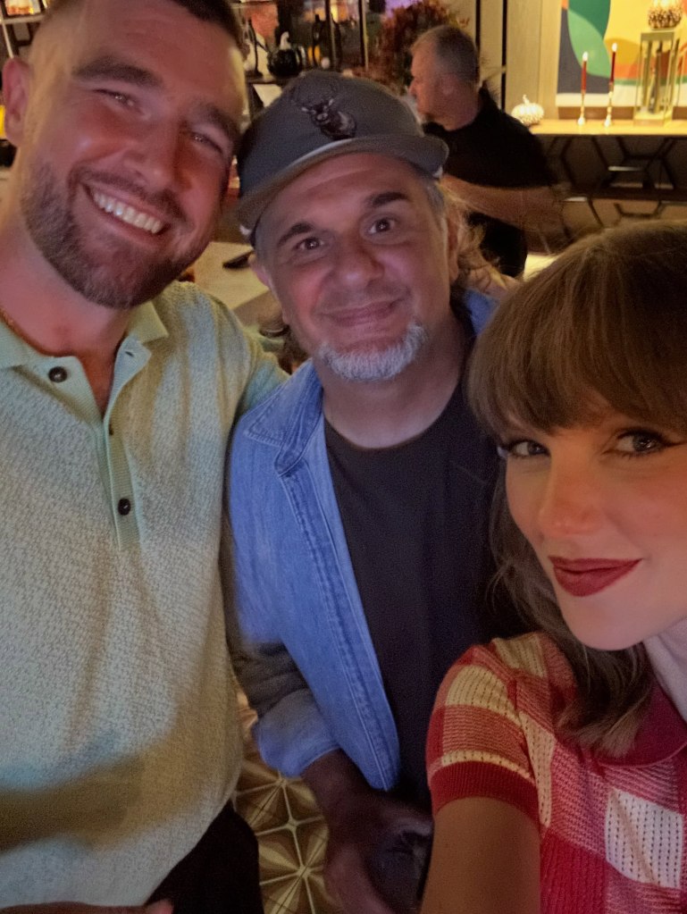 Taylor Swift, Travis Kelce, and another person smiling for a selfie.