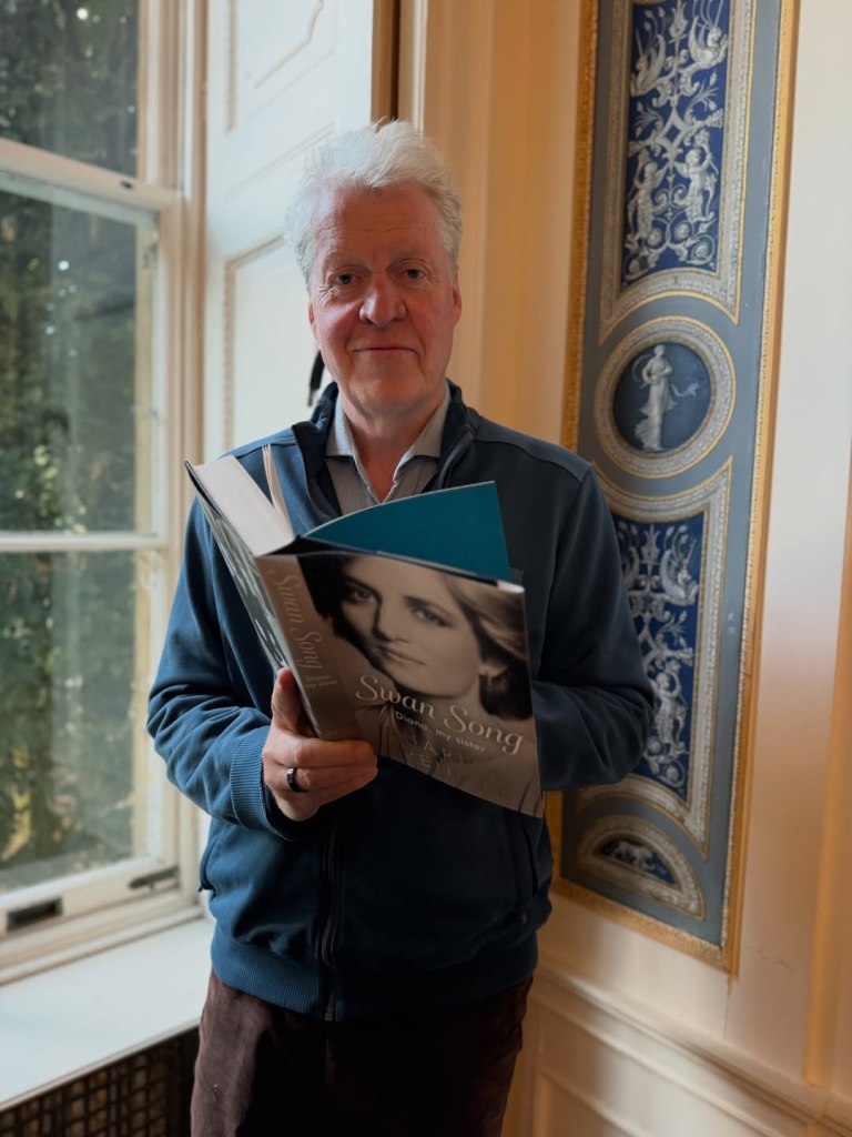 Charles Spencer holds his book 