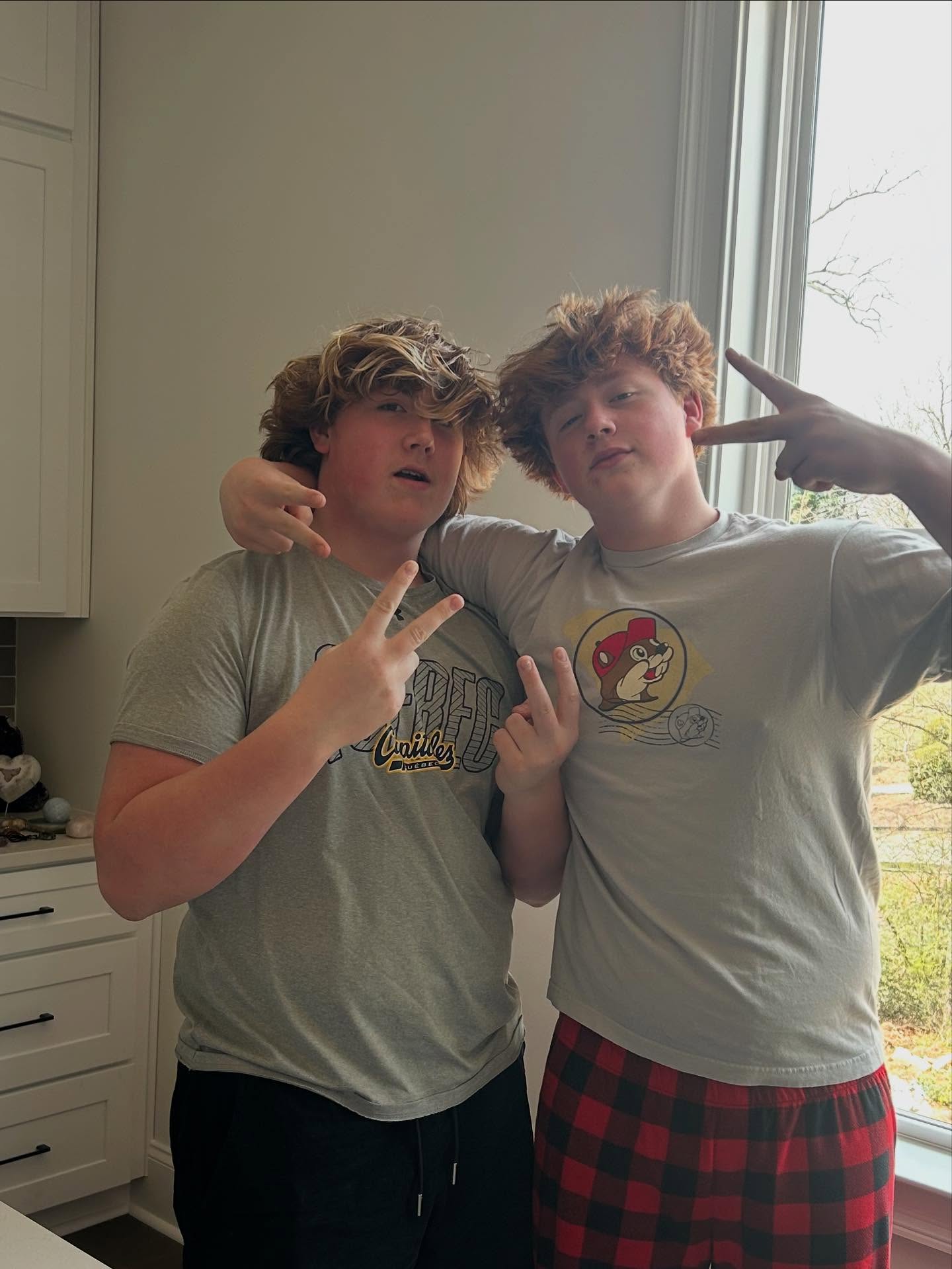 Two boys, KJ Biermann on the left, make hand gestures to the camera.