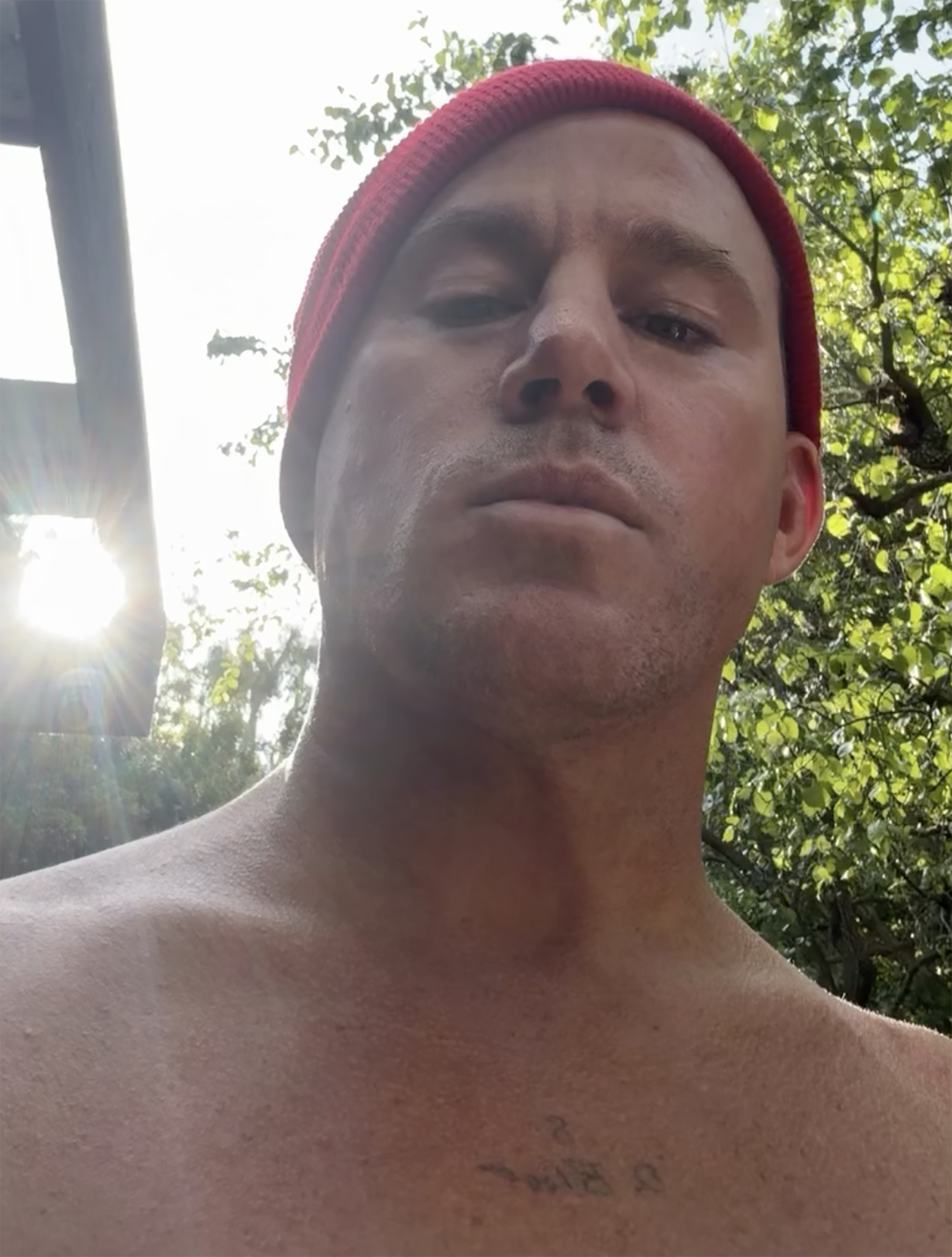 Channing Tatum takes a selfie outdoors in a red beanie.