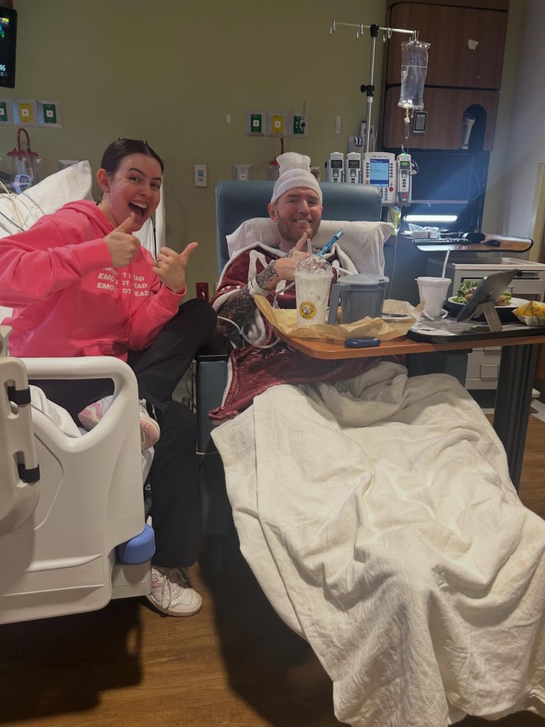 Chad Gilbert of New Found Glory and his partner in a hospital room, both giving thumbs up.